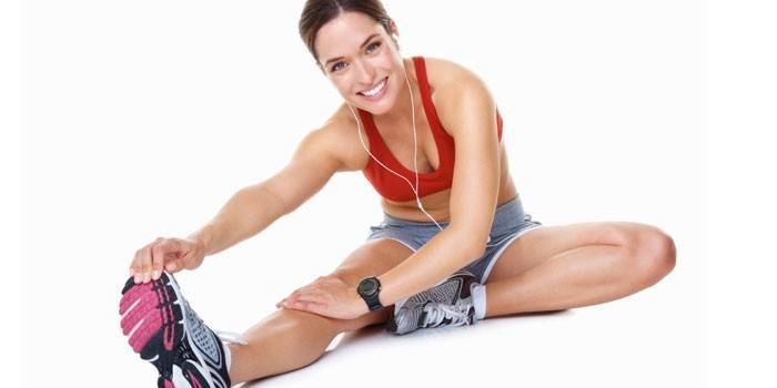 Fille effectue un exercice d'étirement des muscles de la jambe