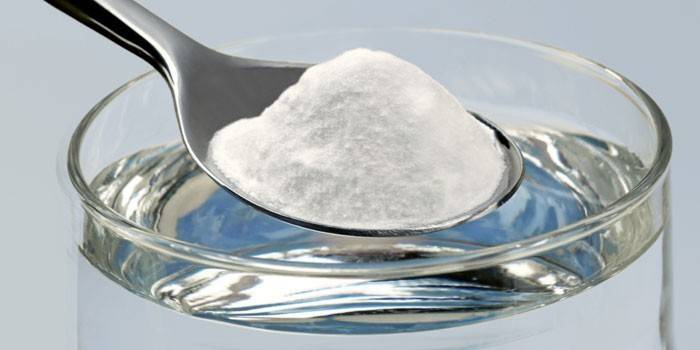 Bicchiere d'acqua e un cucchiaio con soda