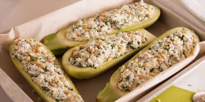 Zucchine tagliate a metà con ripieno di cagliata e pinoli