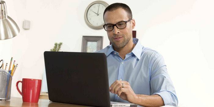 Um homem senta-se em um laptop