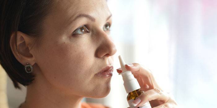 Donna con spray per il naso in mano