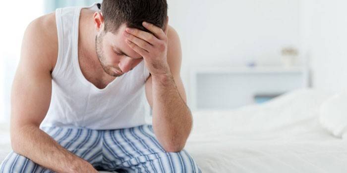 Guy sitzt auf dem Bett