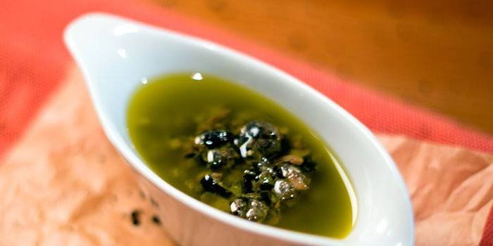 Nước sốt với bạch hoa và cá cơm trong dầu ô liu trong một chiếc thuyền hấp dẫn