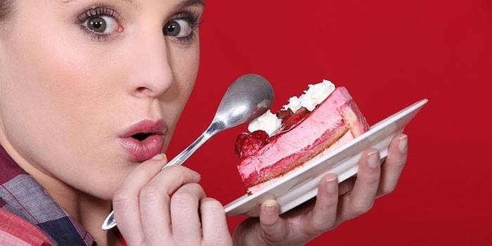 Mädchen mit einem Stück Kuchen auf einer Platte in ihren Händen