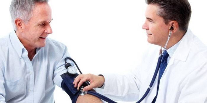 El doctor mide la presión de un hombre.