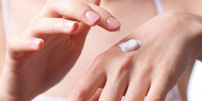 Fille appliquer la crème sur la peau des mains