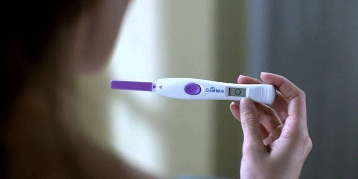 Prueba de embarazo digital en mano de mujer.
