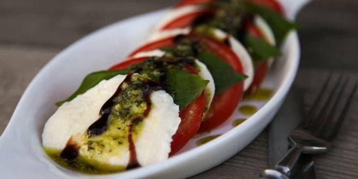 จานสลัด Caprese กับซอสเพสโต้บนจาน