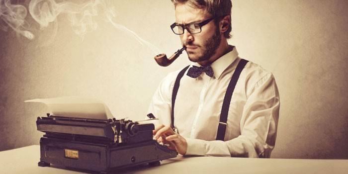 Um homem está digitando em uma máquina de escrever