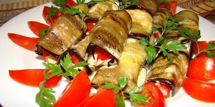 Assiette avec rouleaux d'aubergines fourrés au fromage cottage et à l'ail