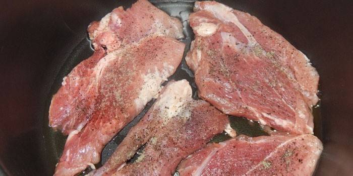 Scaloppine di maiale prima della cottura in una pentola a cottura lenta