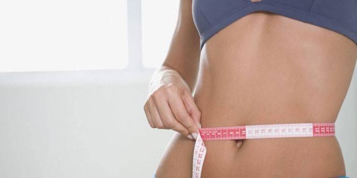 La ragazza misura la vita di un centimetro