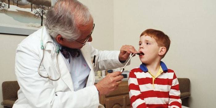 Doktor çocuğun boğazını inceliyor