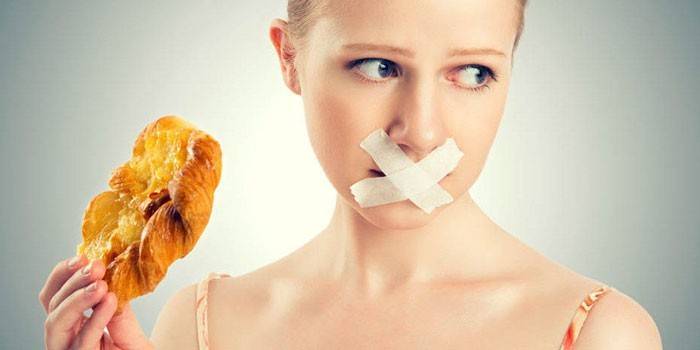 Ragazza con la bocca sigillata e un panino in mano