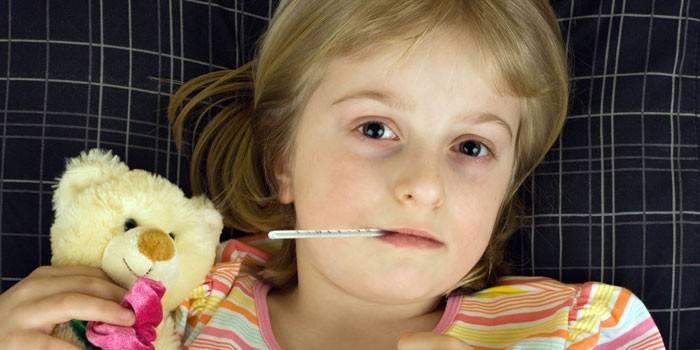 Fille avec un thermomètre dans la bouche