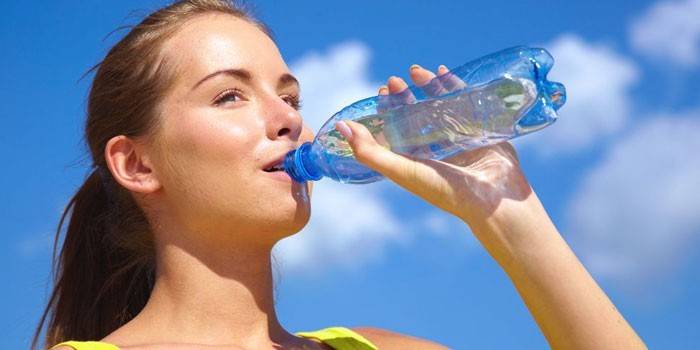 Fille boit de l'eau d'une bouteille