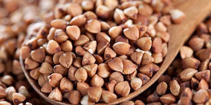 Sêmolas de trigo mourisco em uma colher de pau