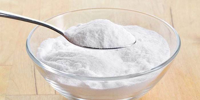 Bicarbonato di sodio in un cucchiaio e piatto