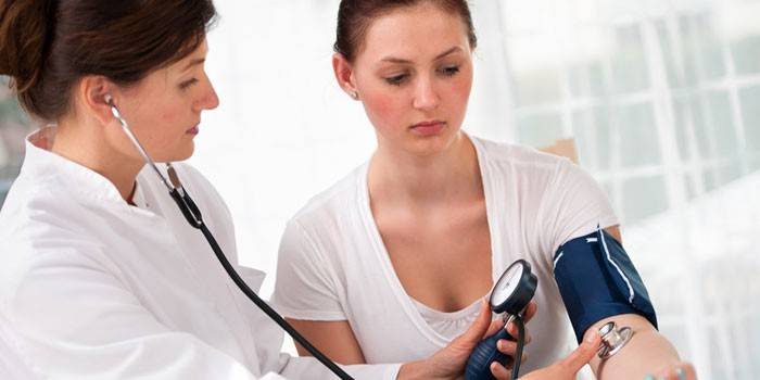 Il medico misura la pressione della ragazza