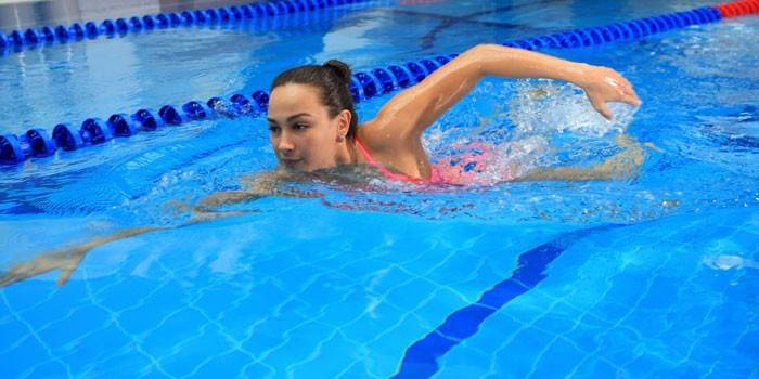 Fata înoată în piscină