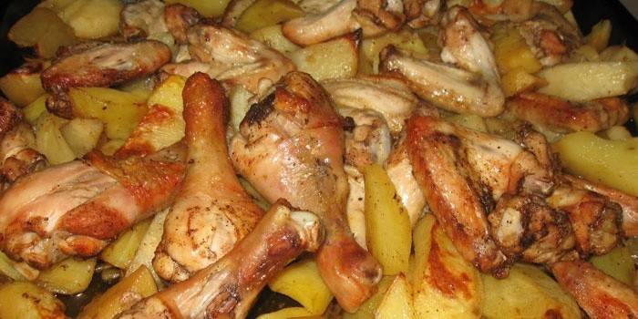 Bir fırın tepsisine patates ile tavuk budu