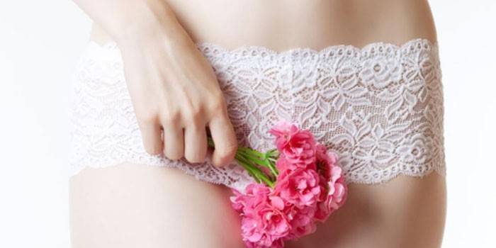 Ragazza che tiene un fiore di fronte