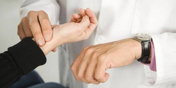 Der Arzt misst den Puls des Patienten
