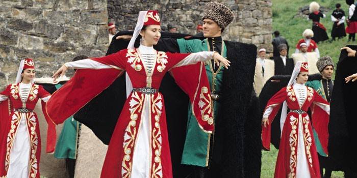 Des femmes et des hommes en costumes tchétchènes dansent