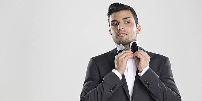 Un homme met un noeud papillon
