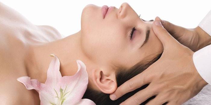 Uma menina recebe uma massagem na cabeça