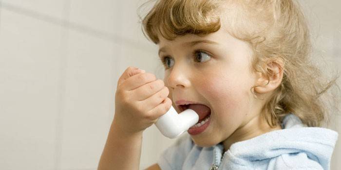 Un enfant avec un inhalateur pour l'asthme à la main