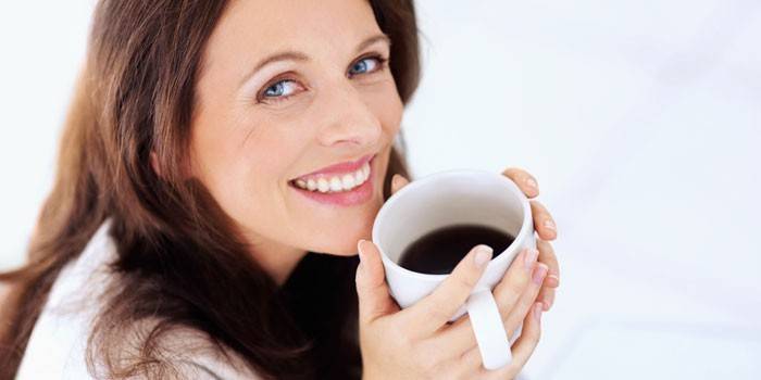 Ang batang babae ay umiinom ng kape