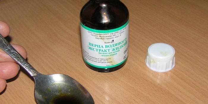 Teinture de poivre et eau dans une cuillère et une bouteille