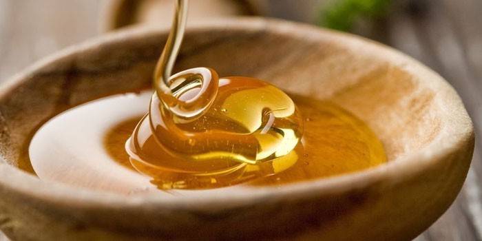 Miel dans une cuillère en bois