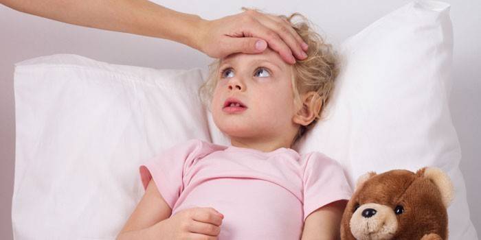 Mamá controla la temperatura de su hija