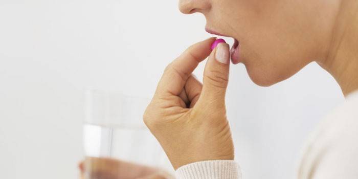 La ragazza beve una pillola