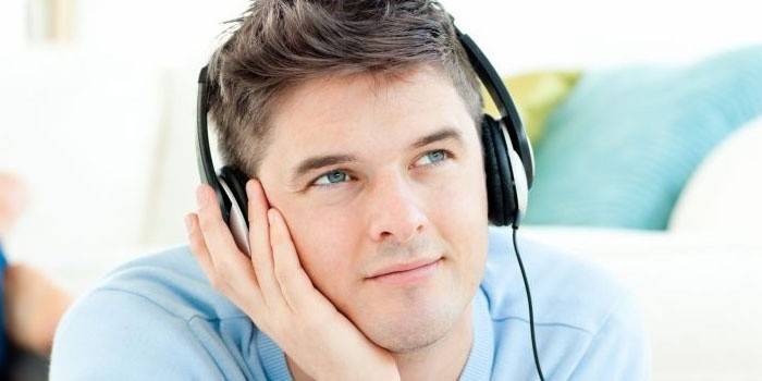 Vaikinas klausosi muzikos per ausines.