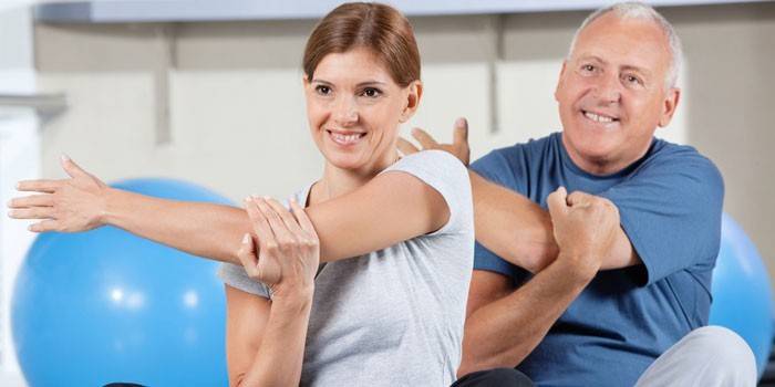 Mann und Frau in einer Klasse in Physiotherapie-Übungen