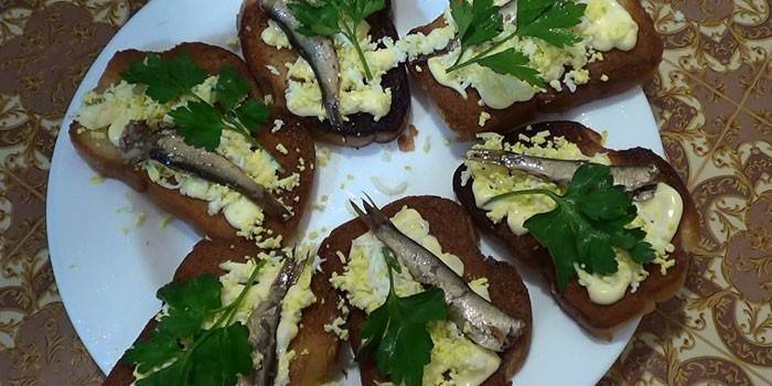 Espadines sobre pan negro con ajo