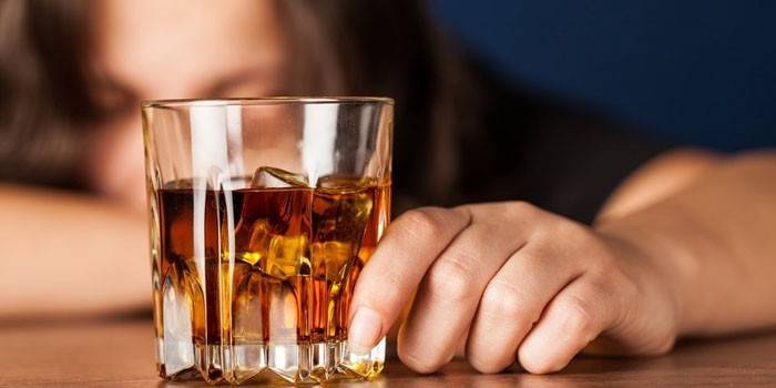 Un pahar de whisky în mâna unei femei
