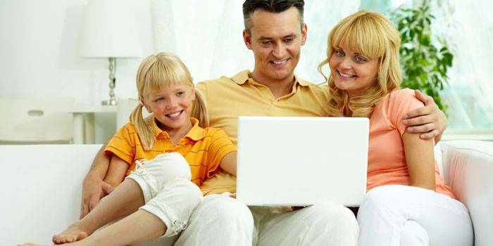 Familie pe canapea cu laptop