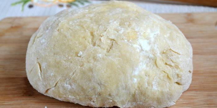 Tigela de massa quebrada de biscoito em uma placa de corte