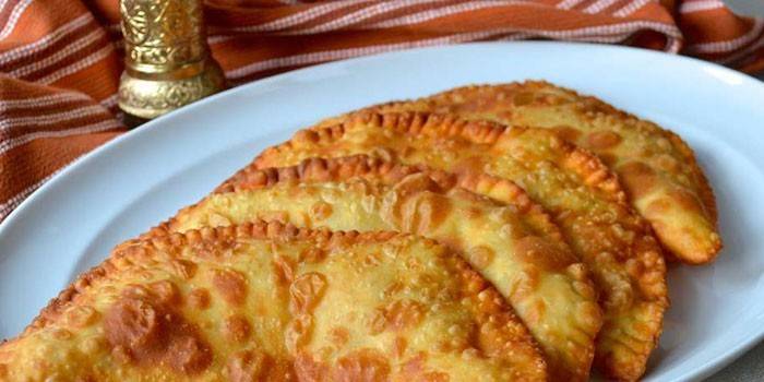 Chebureks trên một bột sữa trứng trên đĩa