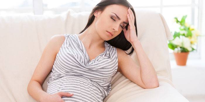 Femme enceinte assise sur le canapé