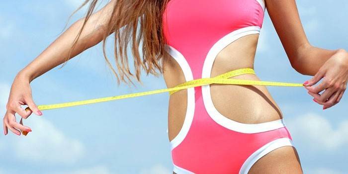La ragazza misura il volume della vita con un centimetro