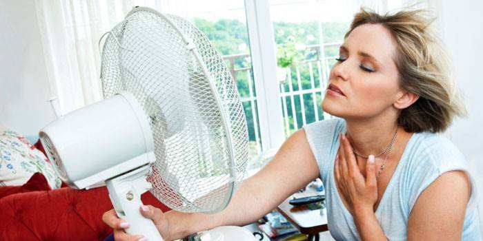 Femeie care stă în fața unui ventilator