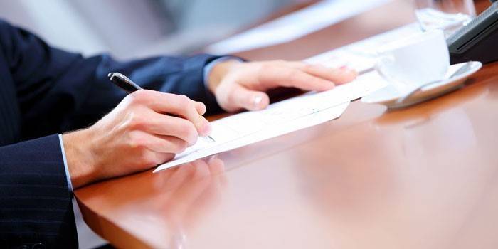 Mies allekirjoittaa paperit