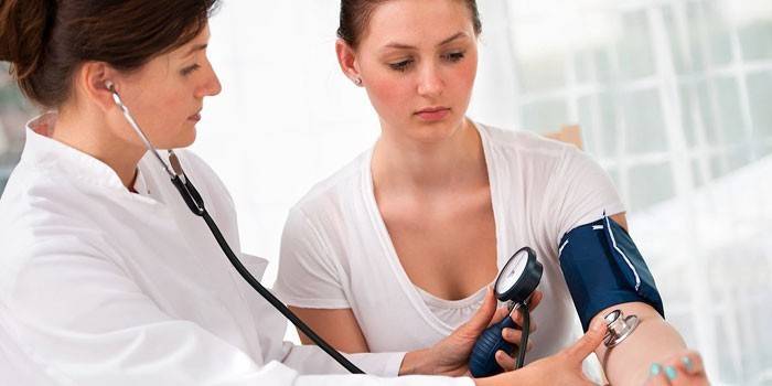 Il medico misura la pressione della ragazza