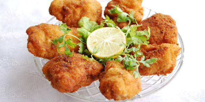 Bereite Hühnernuggets mit Zitrone auf einem Teller