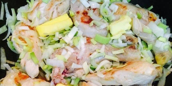 Những miếng thịt gà với tỏi tây và bơ trong chảo